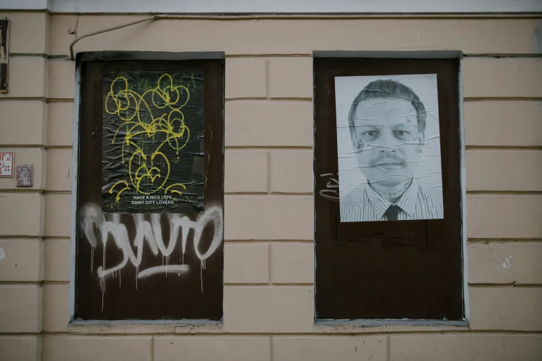 a picture of a man that is on the side of a building, a poster, inspired by Boris Vladimirski, graffiti, without eyebrows, crime photos, jovana rikalo, government archive photograph