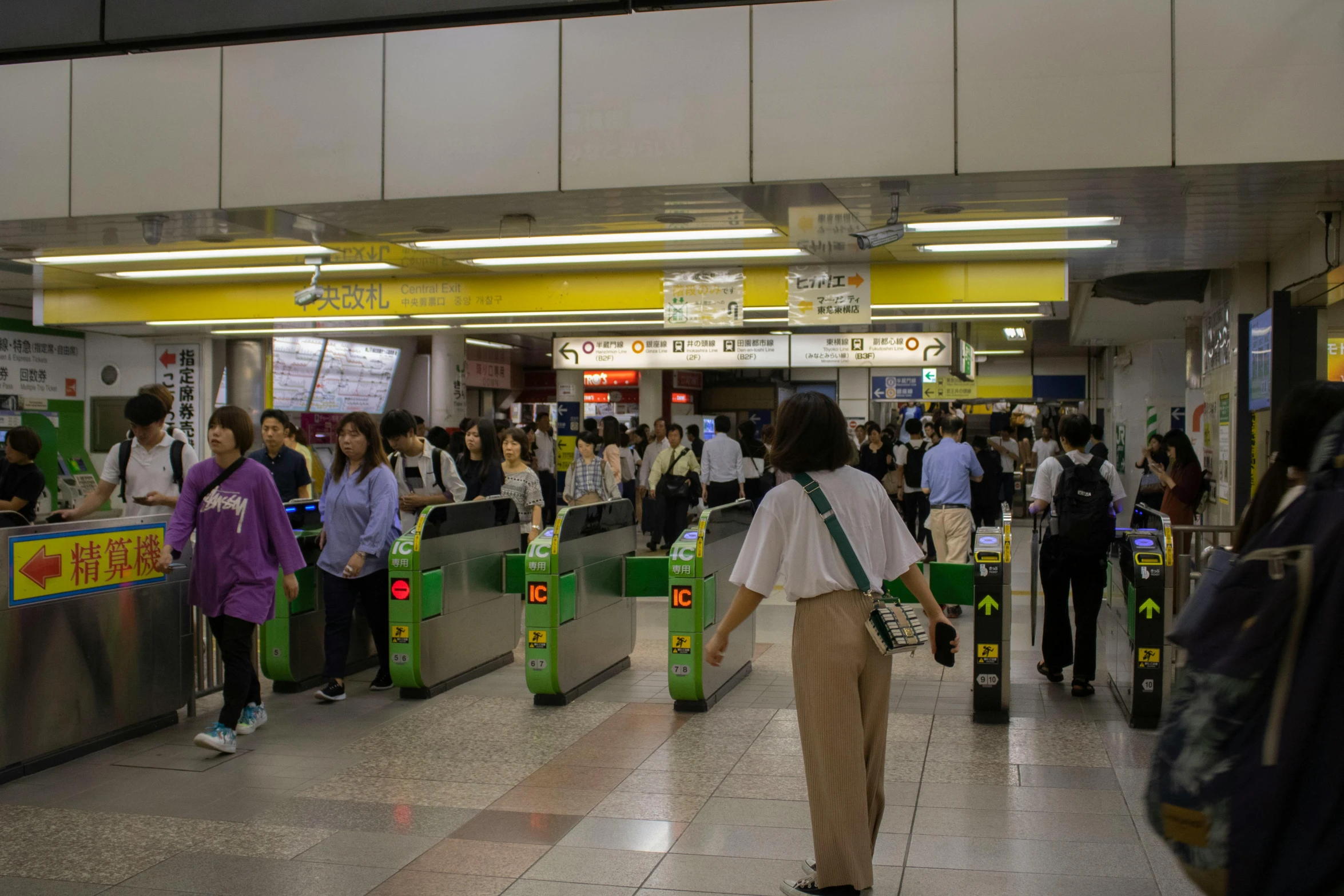 a group of people that are standing in a building, subway station, green and yellow, japanese downtown, 🚿🗝📝