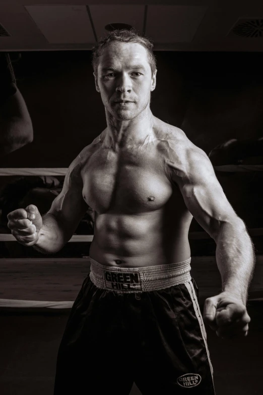 a black and white photo of a man in a boxing ring, inspired by Svetlin Velinov, renaissance, detailed veiny muscles, artem, standing with a black background, taken in the late 2010s
