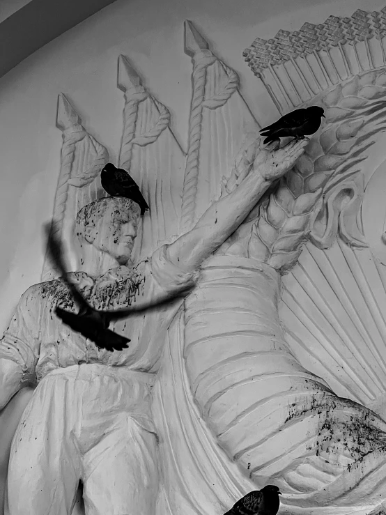 a black and white photo of a statue with birds, a statue, by Luca della Robbia, mexican muralism ) ravi supa, closeup!!!!!!, alexandra fomina, raven wings