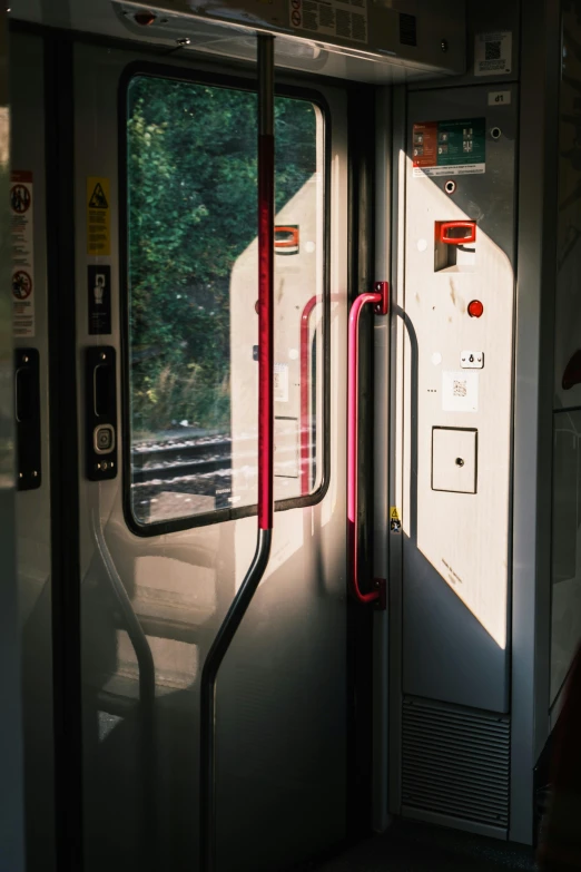 a close up of a train door with a train in the background, unsplash, soft grey and red natural light, exit light, early 2 0 0 0 s, bright lit interiors