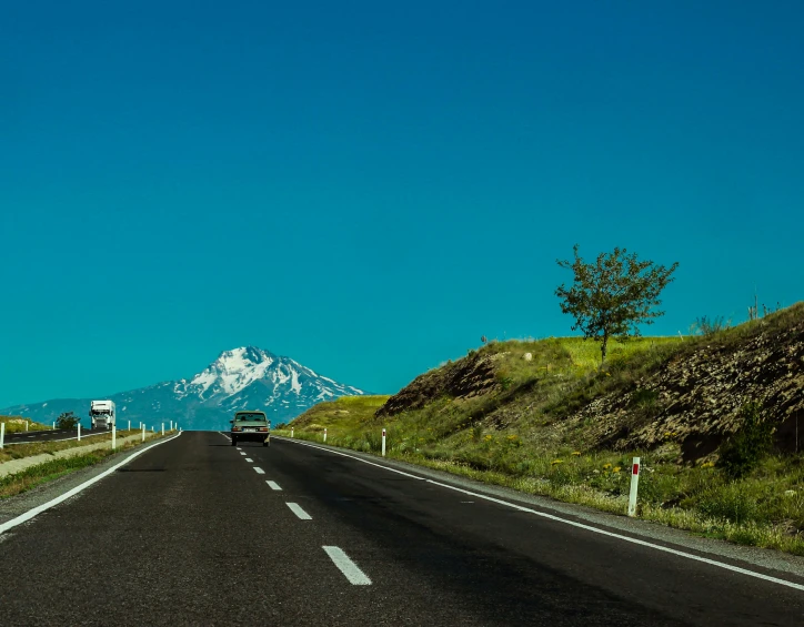 a highway with a mountain in the background, by Muggur, pexels contest winner, hurufiyya, clear blue sky, very asphalt, thumbnail, high resolution photo