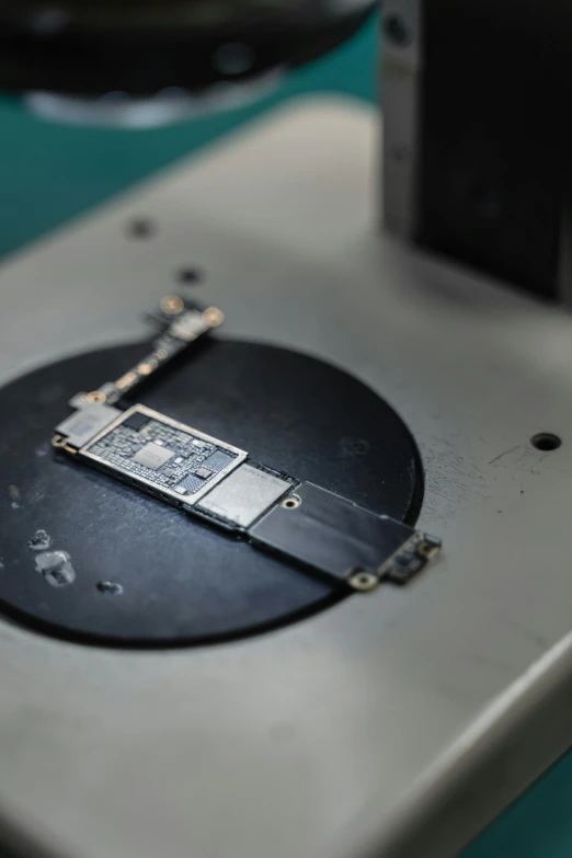 a piece of metal sitting on top of a table, an etching, unsplash, integrated circuit, on an operating table, apple, in a lab