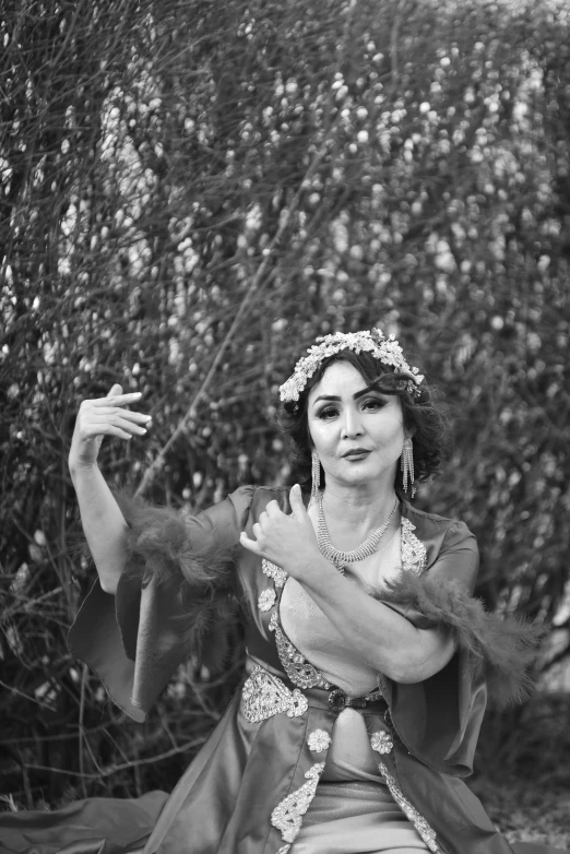 a black and white photo of a woman in a costume, unsplash, arabesque, solemn gesture, flowers, outside, dance meditation