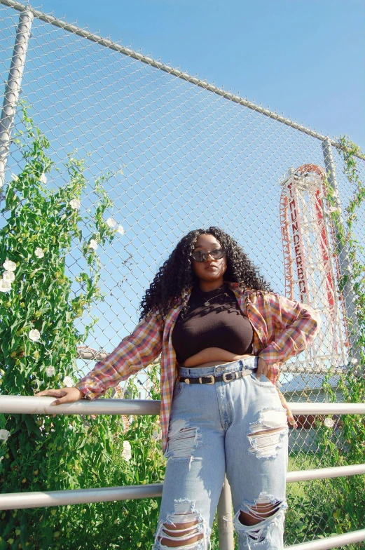 a woman standing in front of a fence, an album cover, trending on bbwchan, wearing a shirt and a jean, nerdy black girl super hero, slide show