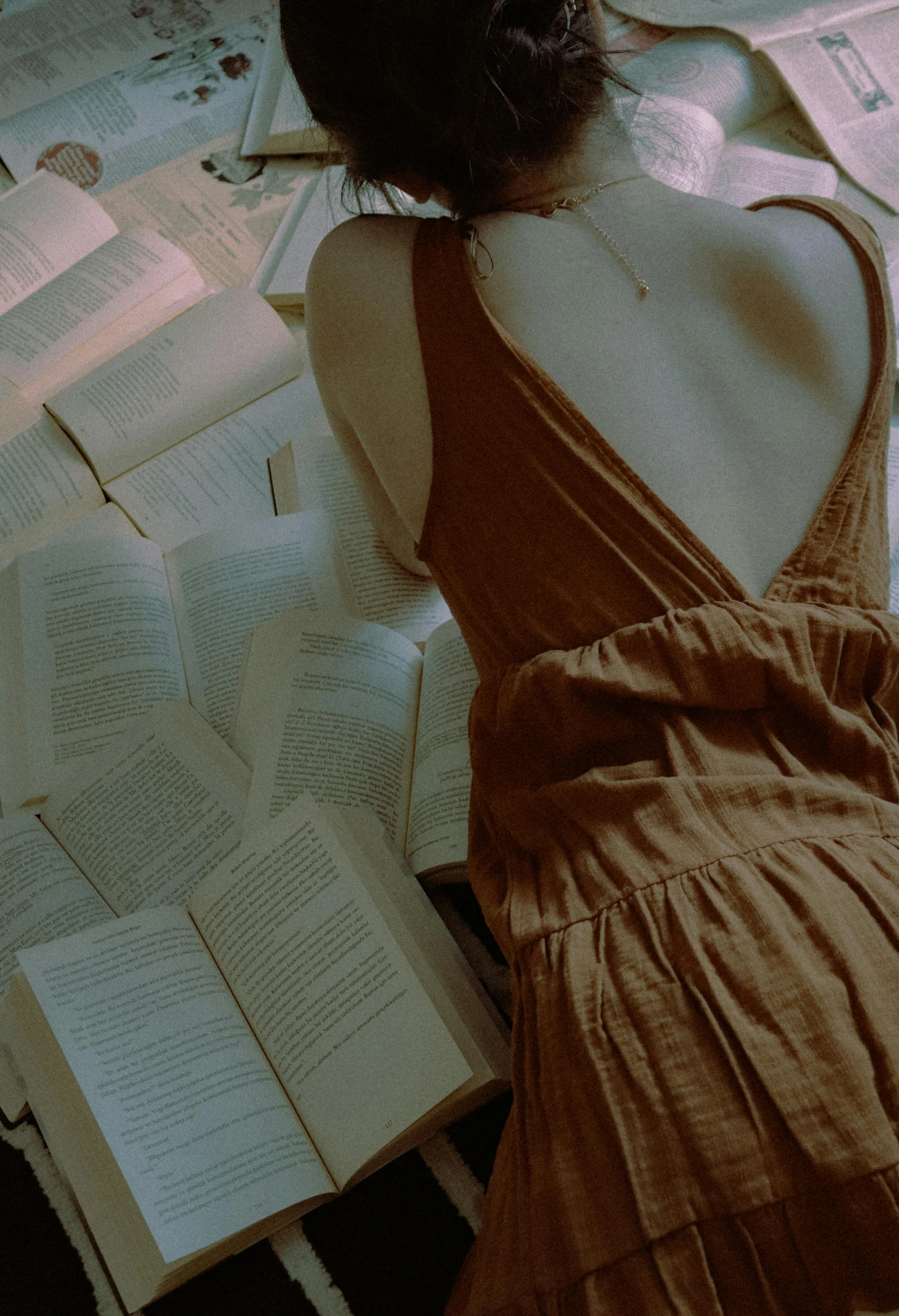 a woman laying on a bed reading a book, by Alexis Grimou, pexels contest winner, aestheticism, open back dress, gif, made of fabric, librarian