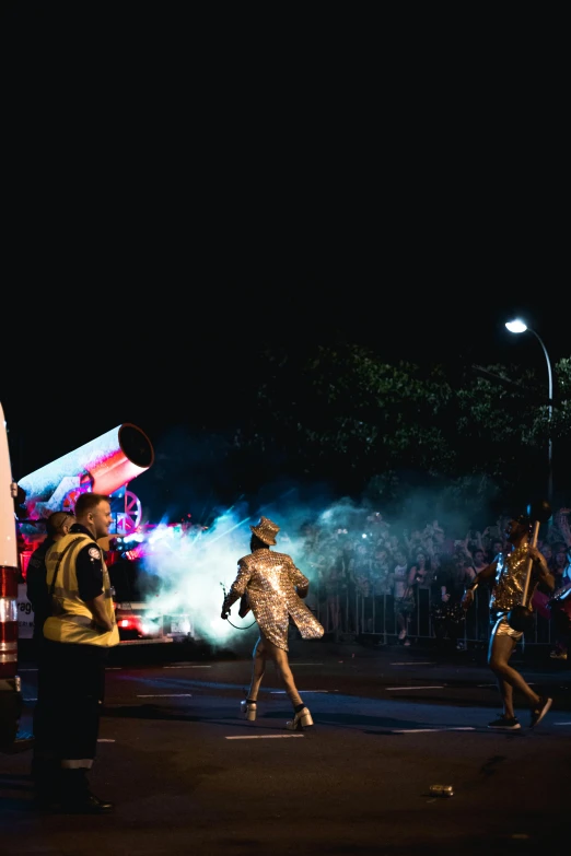 a group of people that are standing in the street, inspired by David LaChapelle, happening, smokey cannons, spaceship night, powerful male tin man, performing