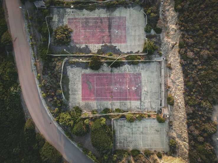 a couple of tennis courts sitting on top of a lush green field, by Carey Morris, unsplash contest winner, ruined, flatlay, malibu canyon, ignant