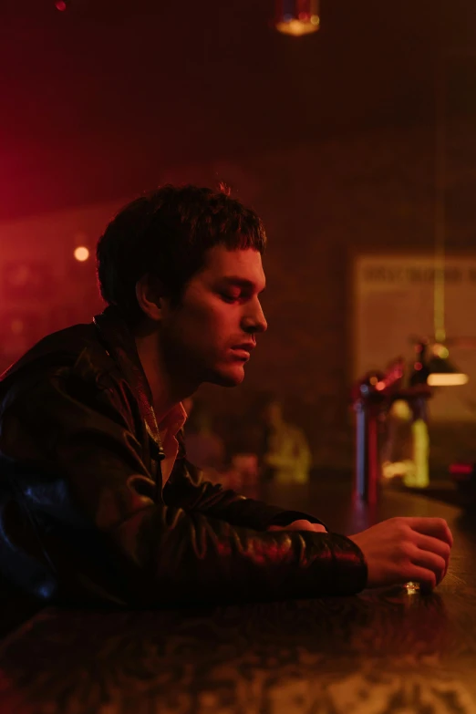a man in a leather jacket sitting at a bar, an album cover, inspired by Nan Goldin, pexels, joe keery, pete davidson, high resolution movie still, romance