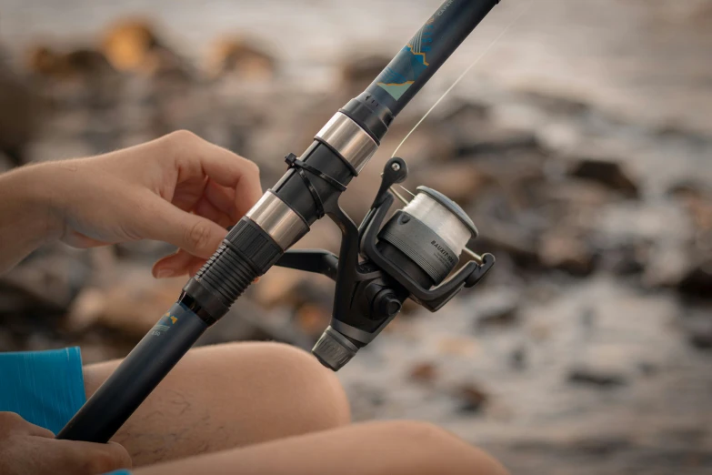 a close up of a person holding a fishing rod, mechanised, wētā fx, easy to use, summer setting