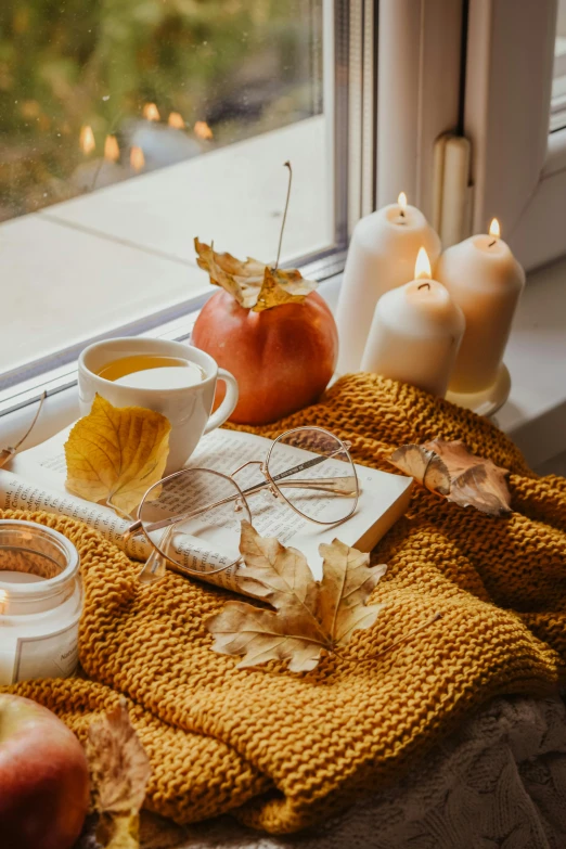 a cup of tea sitting on top of a window sill, a still life, trending on pexels, fall leaves on the floor, lit candles, square, on a yellow canva