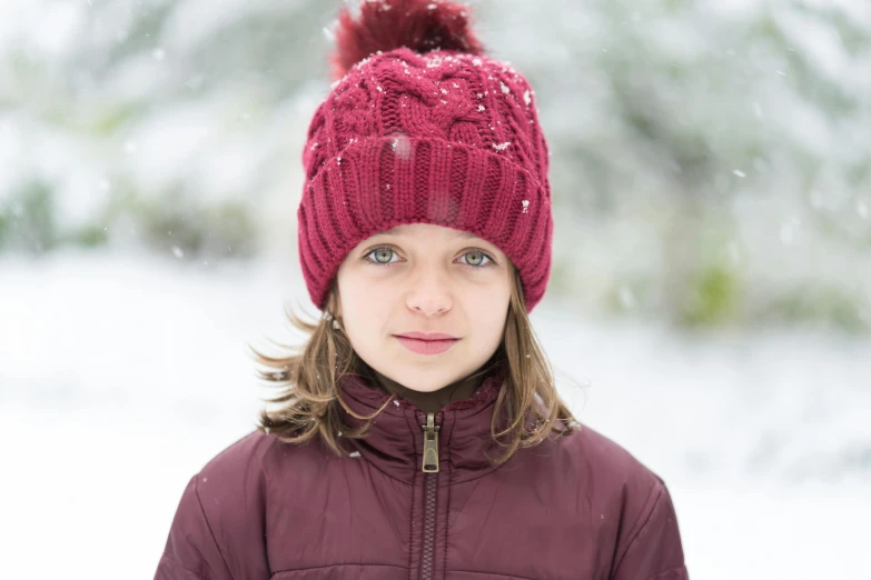 a little girl that is standing in the snow, a portrait, by Helen Biggar, pexels contest winner, maroon hat, avatar image, handsome girl, raspberry