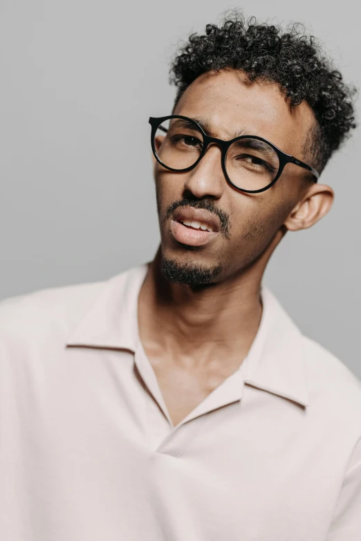 a close up of a person wearing glasses, inspired by Ismail Gulgee, trending on pexels, hurufiyya, male model, tall thin, casual pose, ashteroth