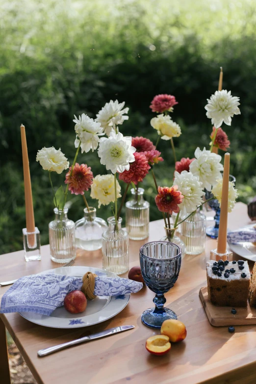 a wooden table topped with plates and vases filled with flowers, fourth of july, full product shot, dahlias, woodstock