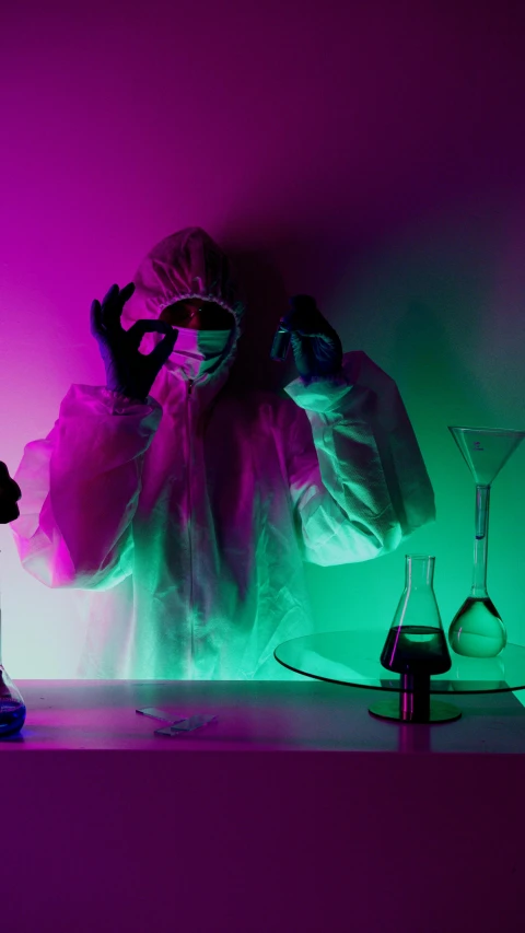 a person standing in front of a purple and green light, by Mark Arian, pexels, holography, with a lab coat, beakers, hazmat, cyan and magenta