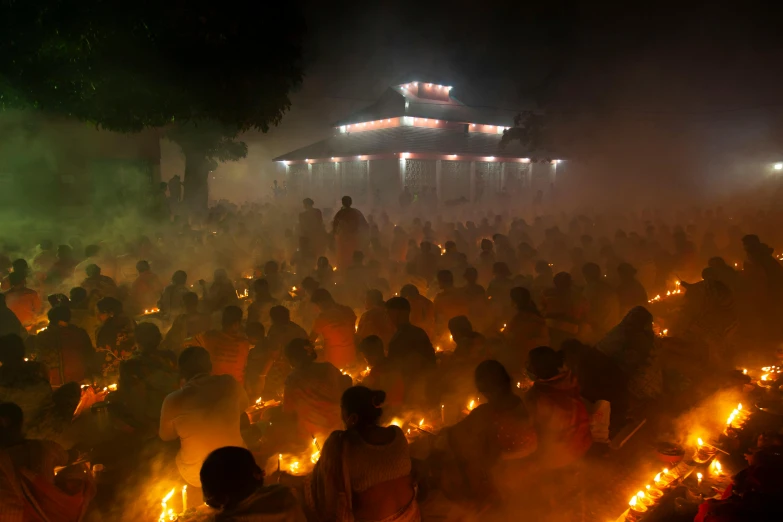 a large group of people holding lit candles, by Dan Content, samikshavad, orange fog, 2022 photograph, temple, puṣkaracūḍa