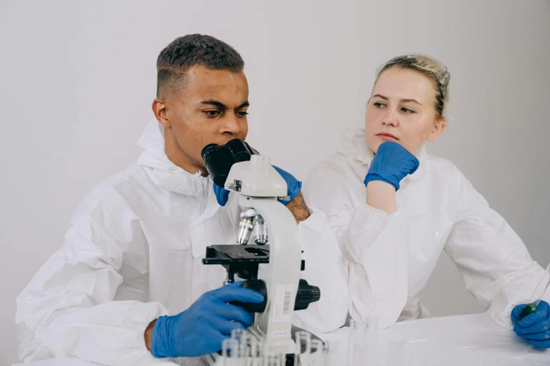 a man and a woman looking through a microscope, pexels contest winner, clean white lab background, background image, looking off to the side, medical dissection