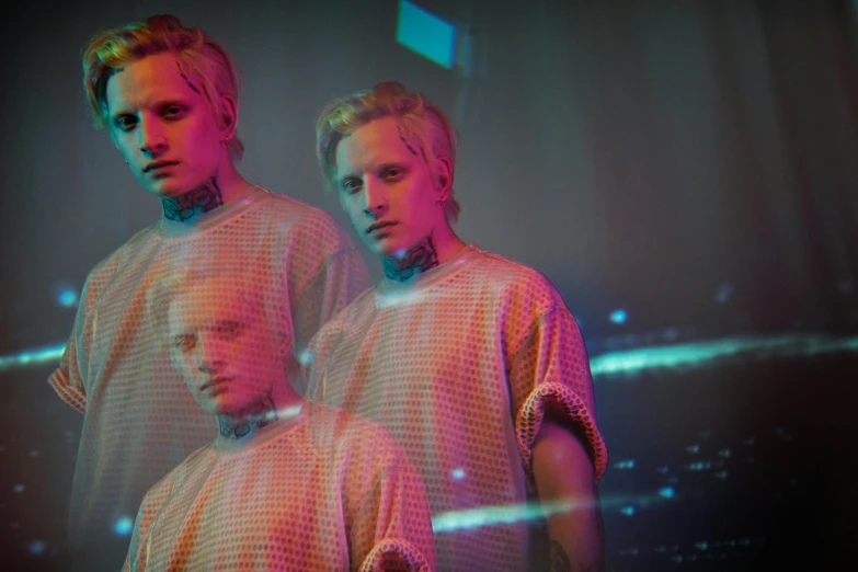 two men standing next to each other on a stage, by Adam Marczyński, holography, cyberpunk dyed haircut, blond ltd, press photos, 3 actors on stage