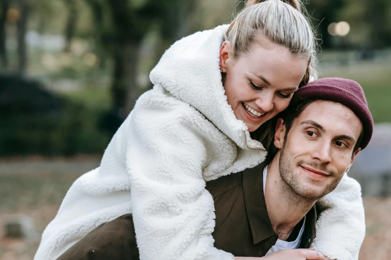 a man carrying a woman on his back, trending on pexels, emma stone in beige coat, sydney hanson, picnic, smiling at camera