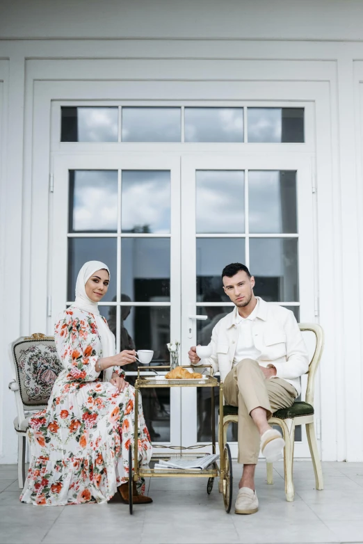 a man and a woman sitting at a table, by Basuki Abdullah, unsplash, hurufiyya, fashion shoot 8k, tea party, white, stately