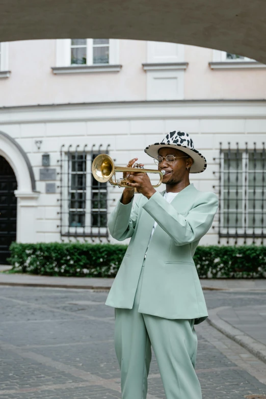 a man in a suit and hat playing a trumpet, by Ottó Baditz, pexels contest winner, harlem renaissance, in front of the house, green suit and bowtie, munich, square