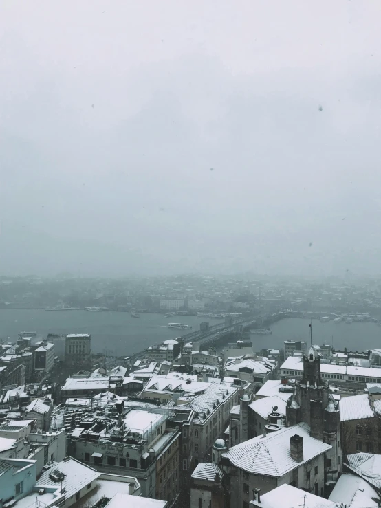 a view of a city from the top of a building, in the middle of a snow storm, snowy fjord, cold as ice! 🧊, new york harbour