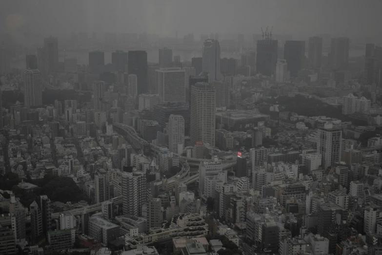 an aerial view of a city with tall buildings, by Tanaka Isson, pexels contest winner, auto-destructive art, very smoky, bleak cityscape background, tokio, gray skies