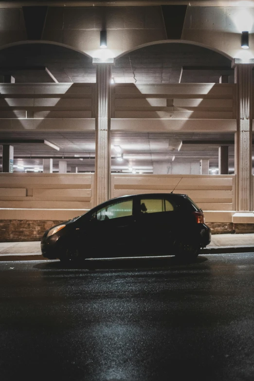 a car parked in front of a building at night, inside of a car, black on black, square, high-quality photo