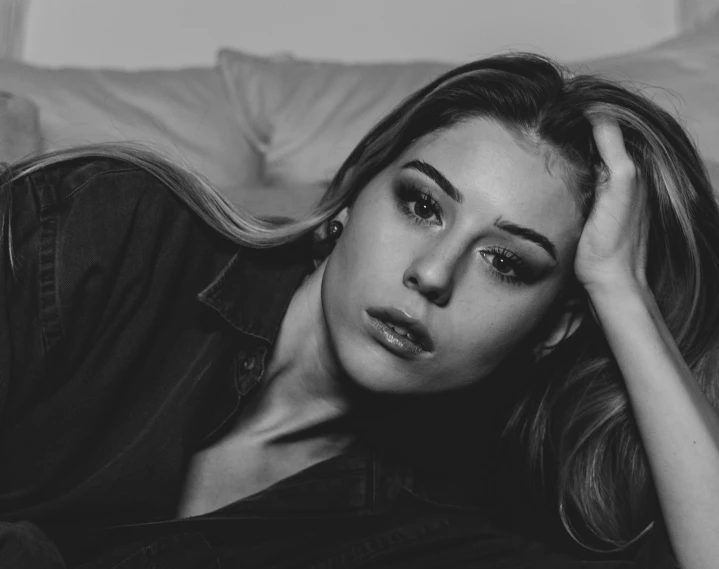 a black and white photo of a woman laying on a couch, a black and white photo, by Emma Andijewska, tumblr, katherine mcnamara inspired, pouty face, photography portrait 4 k, julia sarda