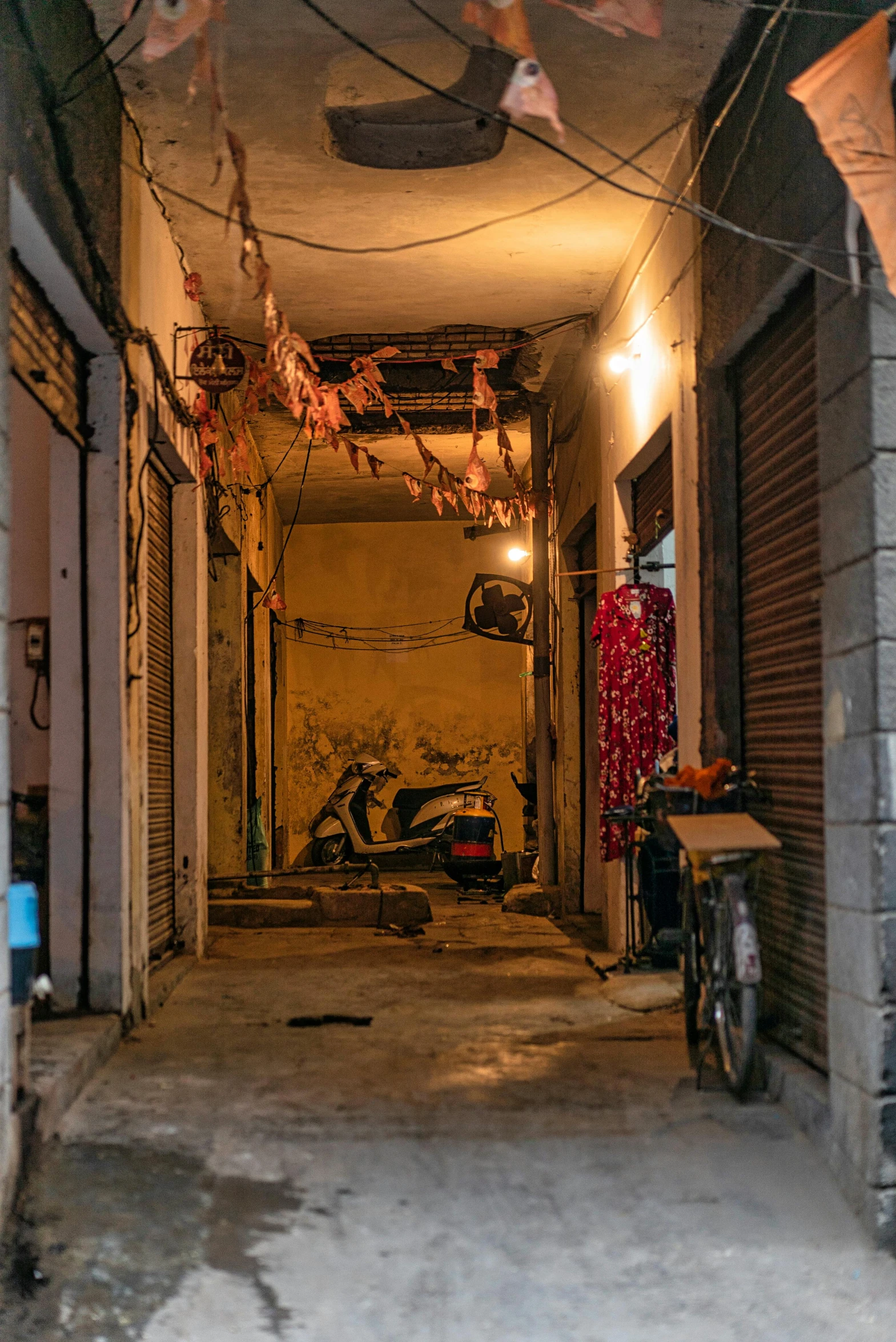 a narrow alley with a motorcycle parked next to it, les nabis, chains dangling from the ceiling, jia ruan, early night, ground-level view