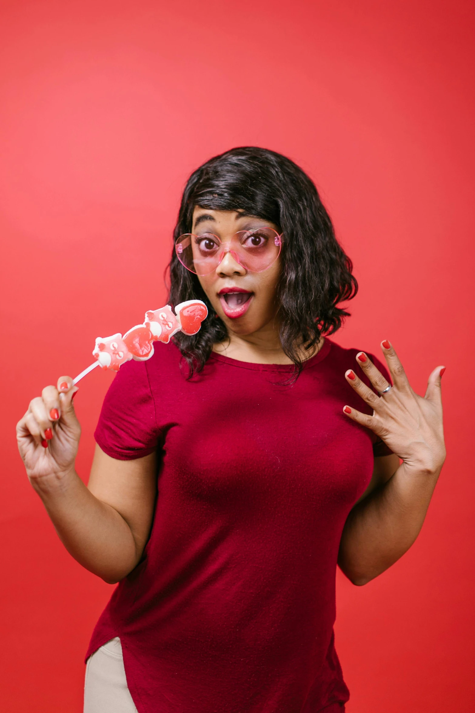 a woman in a red shirt holding two lollipop lollipop lollipop lollipop lollipop lollipop lolli, an album cover, shutterstock contest winner, aida muluneh, dungeons and dragons character, silly playful fun face, in an action pose
