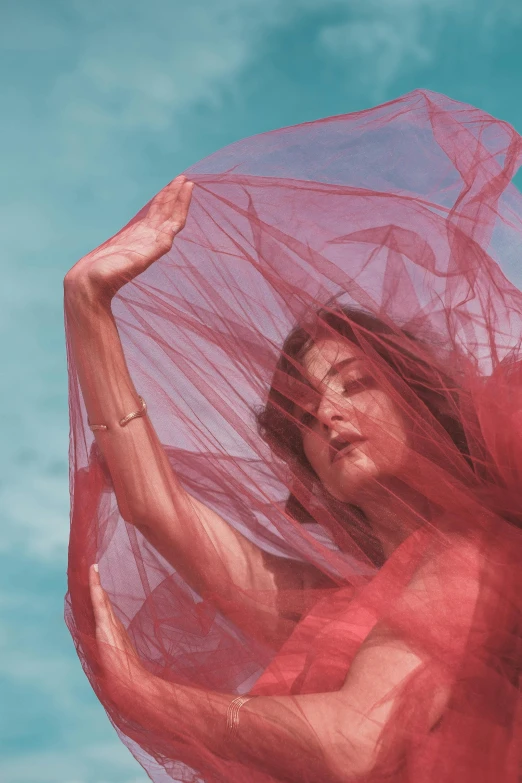 a woman in a red dress holding an umbrella, an album cover, pexels contest winner, diaphanous iridescent silks, phoebe tonkin, reaching for the sky, wearing a veil