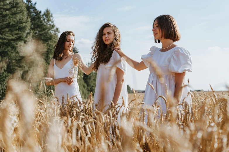 three women in white dresses standing in a wheat field, by Emma Andijewska, pexels contest winner, antipodeans, brunette, avatar image, college girls, high quality product image”