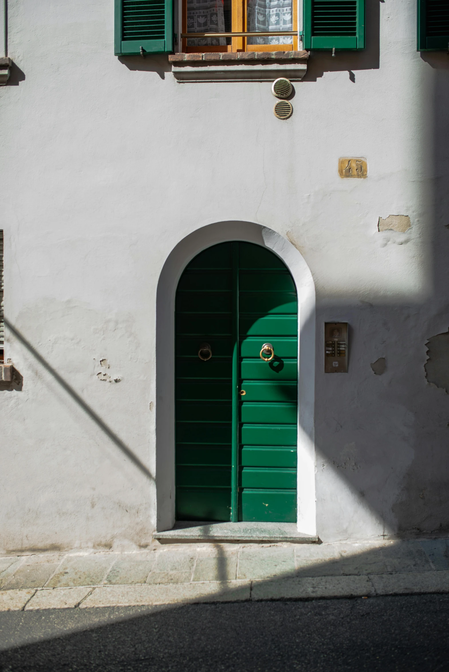 a white building with green shutters and a green door, by Vito D'Ancona, renaissance, keyhole, solid colours, one green