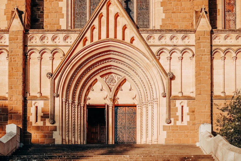 a church entrance with steps leading up to it, inspired by Sydney Prior Hall, unsplash contest winner, romanesque, ivory and copper, chrome cathedrals, victorian arcs of sand, bathed in golden light