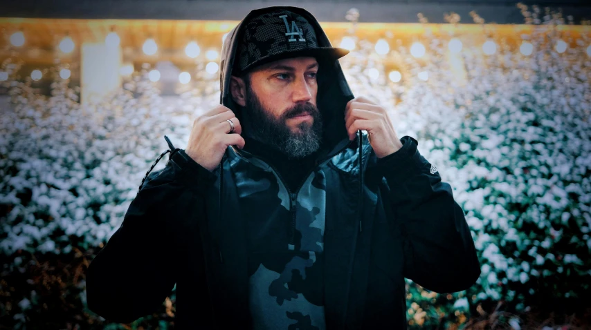 a man in a hoodie talking on a cell phone, unsplash, lyco art, with a beard and a black jacket, wearing camo, looking towards camera, avatar image