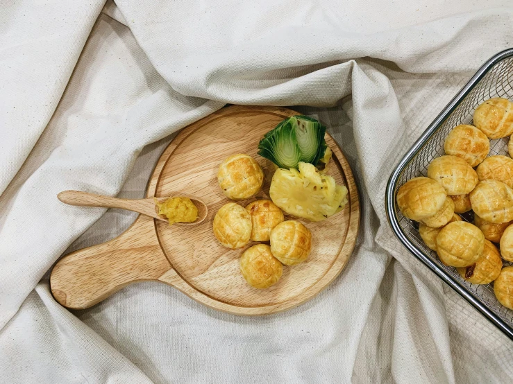 a couple of trays of food sitting on top of a table, a still life, inspired by Barthélemy Menn, trending on unsplash, tribbles, holding a wood piece, with yellow cloths, on a wooden tray