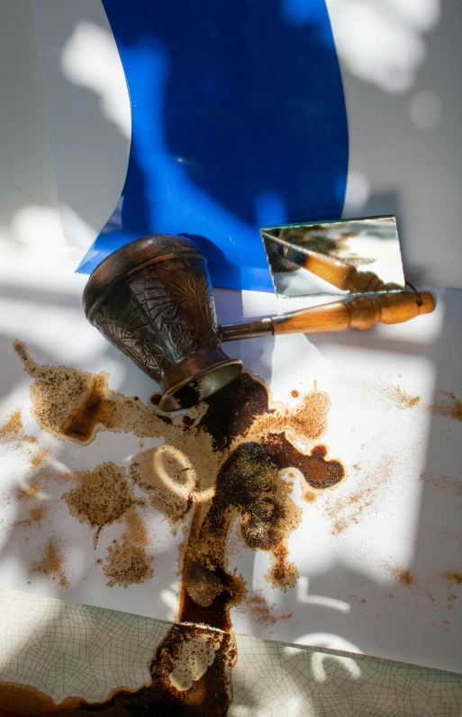 a blue vase sitting on top of a piece of paper, a picture, spilt coffee, pestle, deteriorated, orthodox