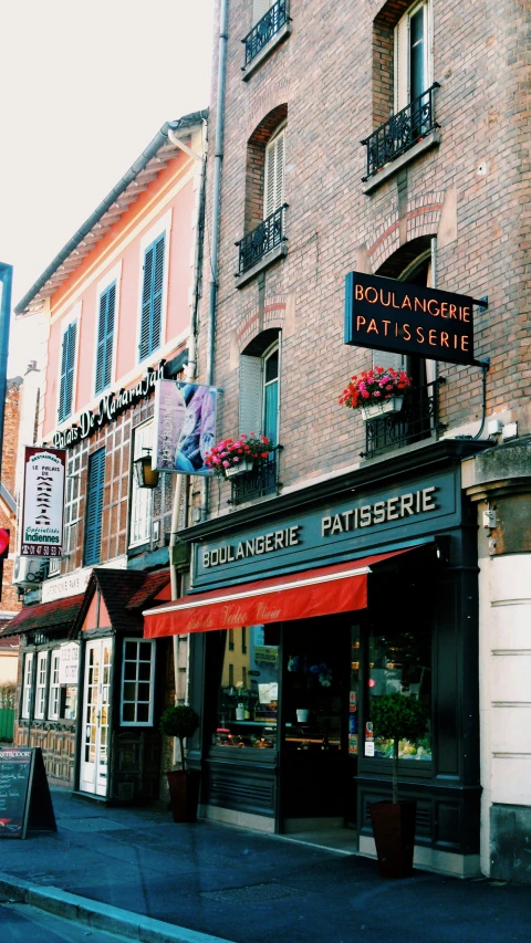 a couple of buildings that are next to each other, inspired by Pierre Toutain-Dorbec, pexels, renaissance, cute bakery shop, 1999 photograph, colorful signs, conde nast traveler photo