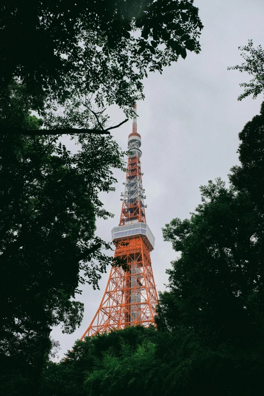 a tall tower surrounded by trees on a cloudy day, a picture, unsplash contest winner, sōsaku hanga, orange and white color scheme, 🚿🗝📝, harajuku, photo on iphone