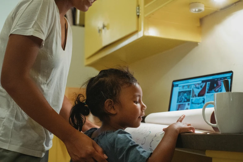 a woman standing next to a little girl in a kitchen, a child's drawing, computer art, using a macbook, photo mid shot, avatar image