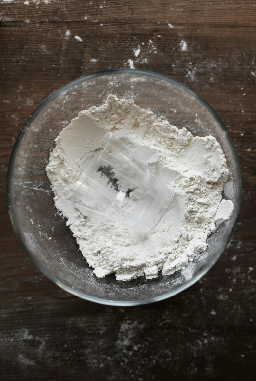 a bowl of flour sitting on top of a wooden table, inspired by Josefina Tanganelli Plana, reddit, process art, white grey color palette, birdseye view, layer upon layer, baking cookies