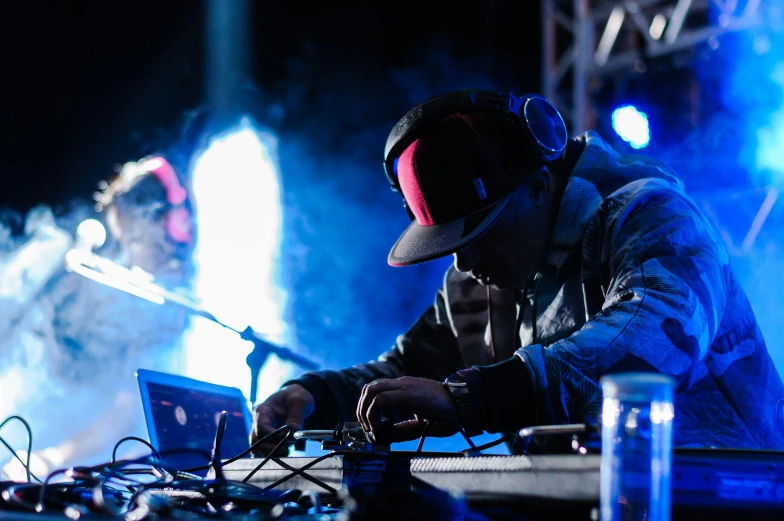 a man that is sitting in front of a laptop, unsplash, graffiti, dj at a party, glowing eyes in helmet, performing on stage, avatar image