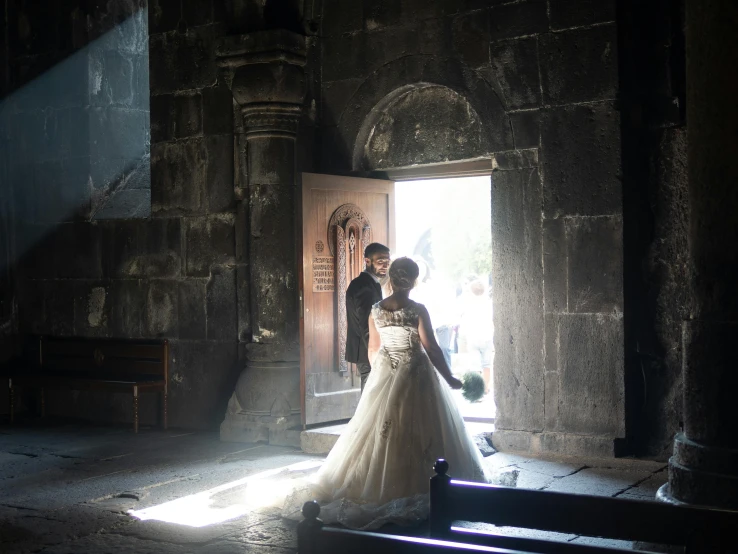 a bride and groom standing in the doorway of a church, pexels contest winner, happening, georgic, back - lit, ( ( theatrical ) ), black