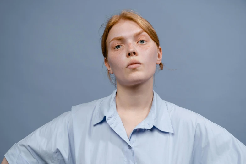 a woman standing with her hands on her hips, a character portrait, trending on pexels, hyperrealism, wearing a light blue shirt, wrinkled big cheeks, a redheaded young woman, without duplicate image