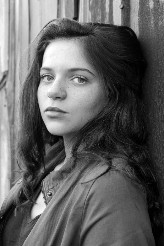 a black and white photo of a woman leaning against a wall, portrait of white teenage girl, cast, taken in the late 2010s, promotional image