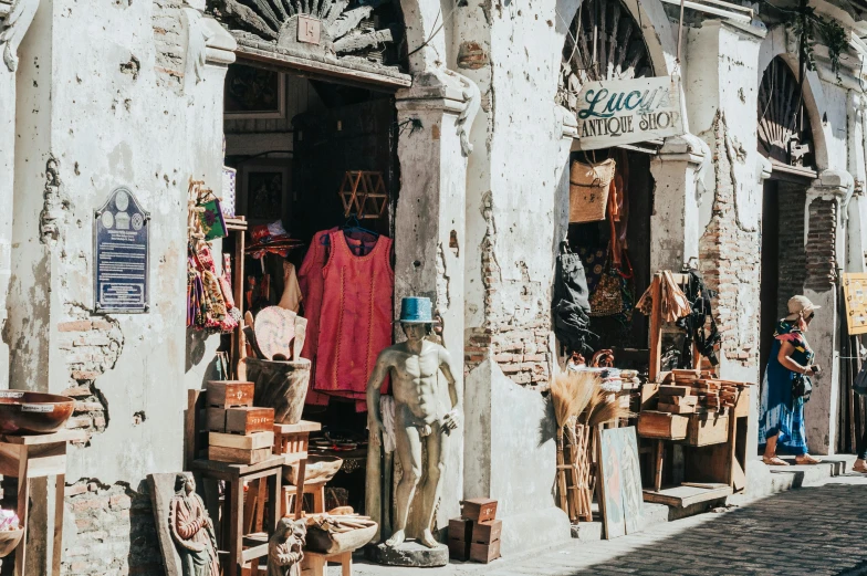 a couple of people that are standing in front of a building, a statue, pexels contest winner, renaissance, market stalls, rustic, belongings strewn about, tlaquepaque