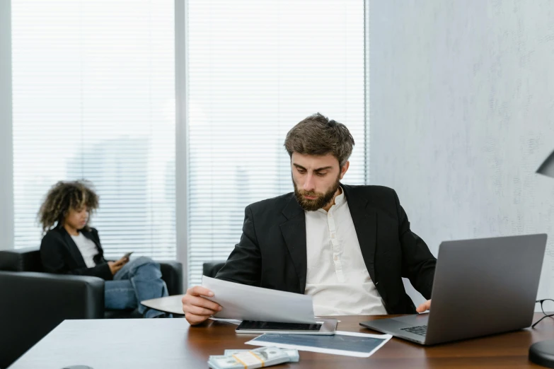 a man sitting at a table with a laptop and papers, a cartoon, pexels contest winner, hurufiyya, medium shot of two characters, high quality photo, serious business, open office