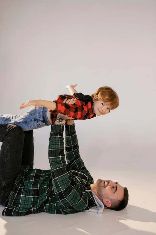 a man holding a little boy up in the air, inspired by The Family Circus, pexels contest winner, visual art, flannel, studio shoot, greg rutkowski and alex ross, a handsome