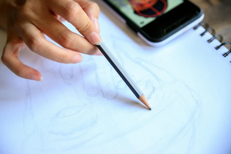 a person drawing on a piece of paper with a pencil, a drawing, by Adam Marczyński, trending on pexels, analytical art, mobile game art, 9 9 designs, smartphone photography, dissection sketch